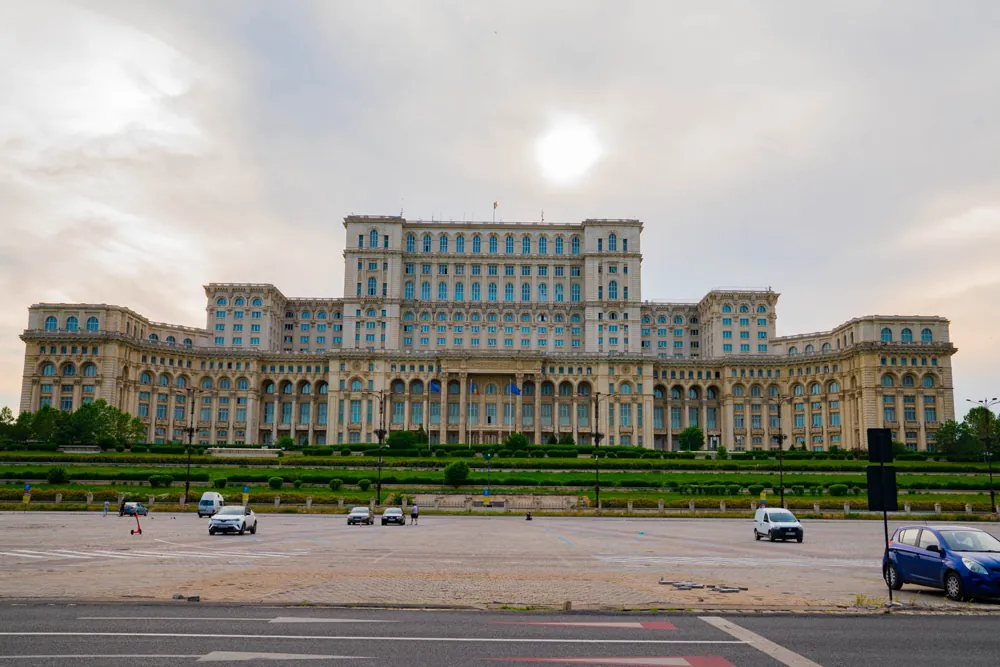 The broad façade of the Palace of Parliament in Bucharest, seen from across the boulevard.