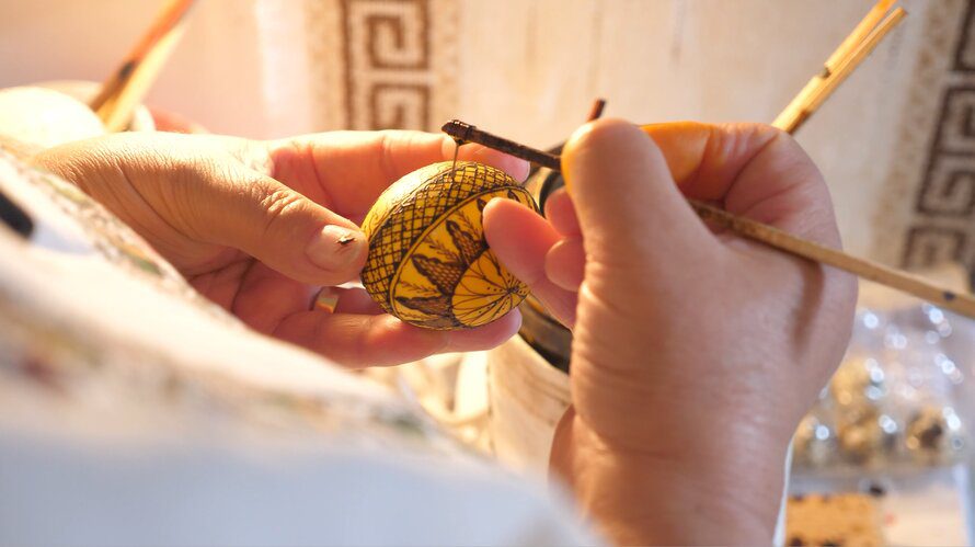 Person painting intricate egg design