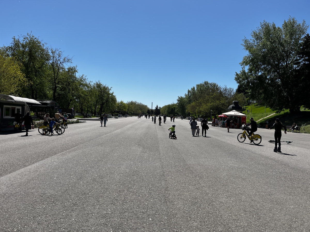 Wide main boulevard with cyclists and skaters in Tineretului Park, Bucharest