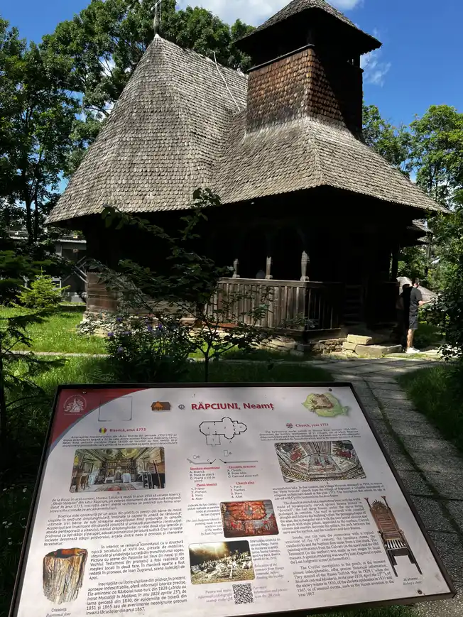 Wooden church from Răpciuni in Neamț, with the museum information board in front.