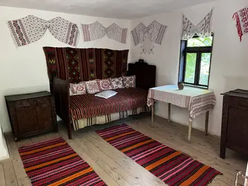 Interior bedroom with traditional textiles and a decorated bed.