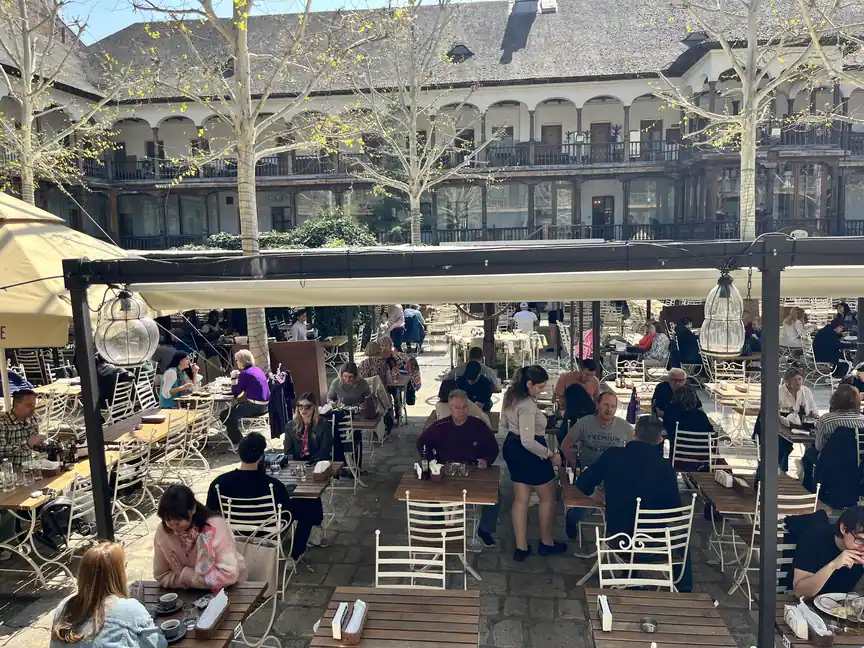 Wide view of Hanu’ lui Manuc’s busy outdoor courtyard and wooden galleries.