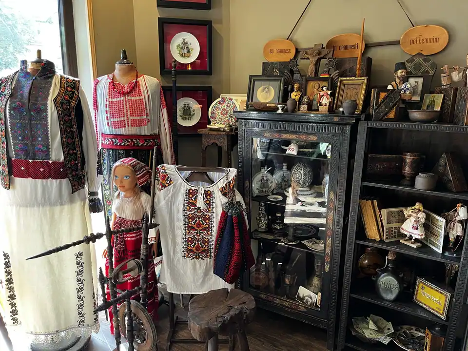 Display of embroidered Romanian folk blouses, ceramics and traditional objects at Restaurant Ceaun.