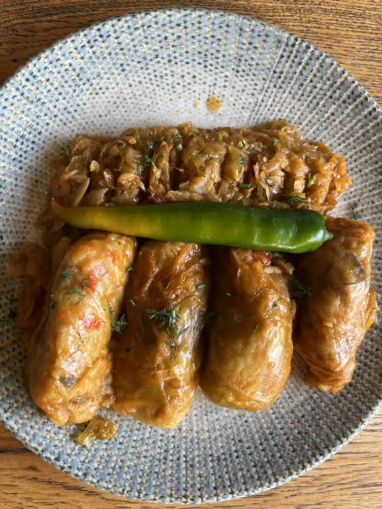 Romanian sarmale cabbage rolls with shredded cabbage and a green pepper at Restaurant Ceaun.