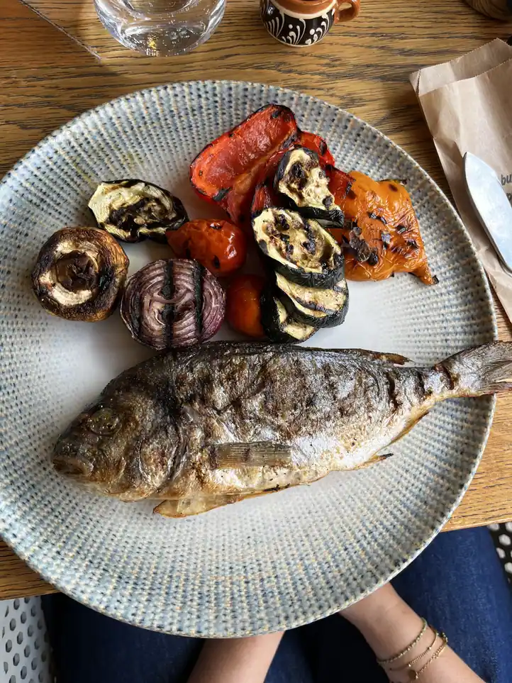 Whole grilled fish with grilled vegetables at Restaurant Ceaun in Bucharest.