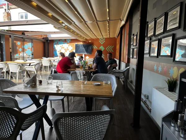 Bright covered seating room at Restaurant Ceaun with roof and windows.