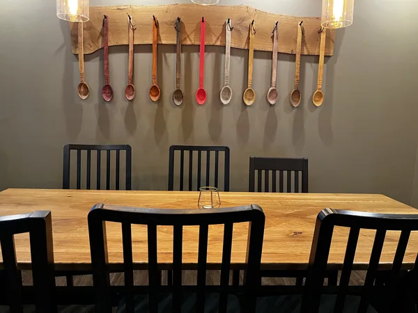 Carved wooden spoons displayed above a table at Restaurant Ceaun.