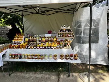 Outdoor stall with jars of honey, jams and local products.