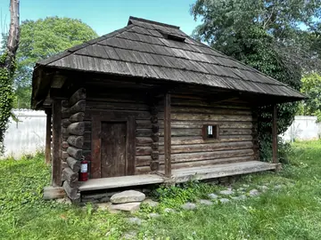 Low log house with a deep roof and open front porch.