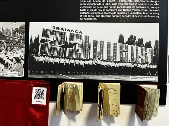 Communist propaganda photographs and open party booklets displayed beneath them.