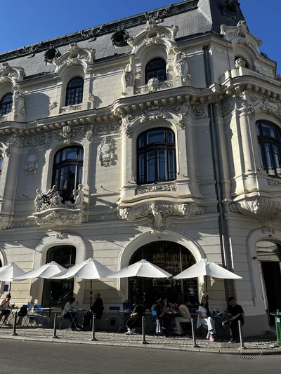 Street view of the historic Casa Mița Biciclista building and its outdoor tables