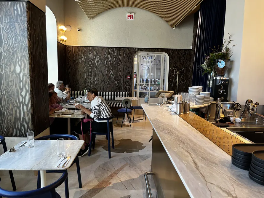 Ground-floor brasserie with small dining tables and a long counter at La Mița Biciclista