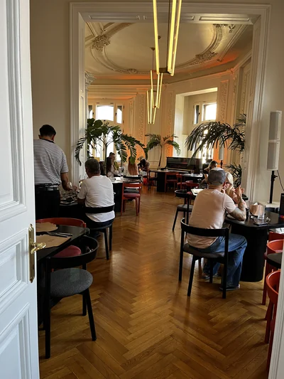 View through a doorway into the salon with decorative ceilings and tall plants