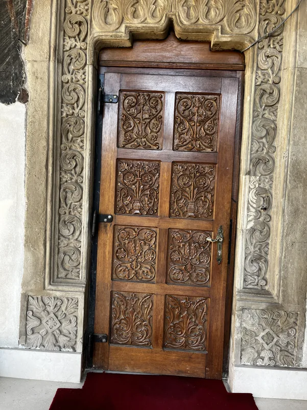 Carved wooden church door within an ornamental stone portal at Kretzulescu Church.