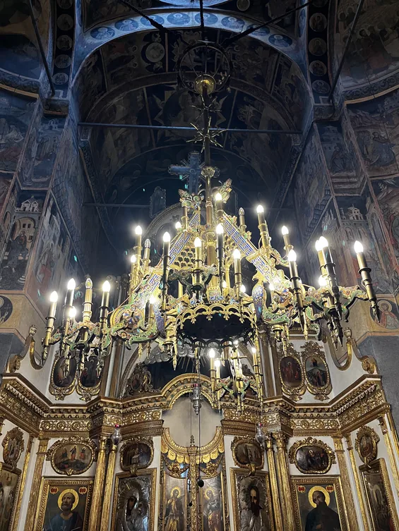 Lit chandelier before the upper frescoes and iconostasis in Kretzulescu Church.
