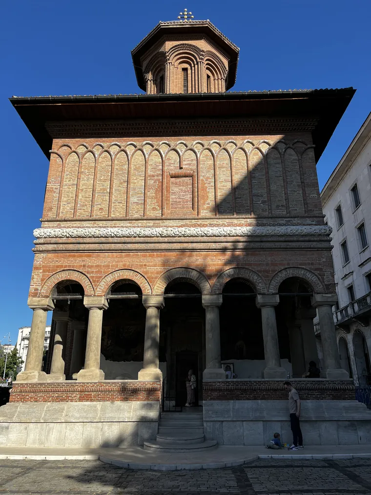Front view of Kretzulescu Church showing its red-brick façade, open porch, and central tower.