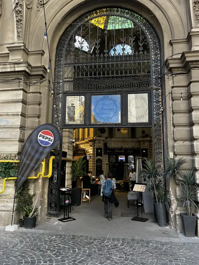 Carved arch and wrought-iron gate at the Eugeniu Carada entrance to Macca–Villacrosse Passage.