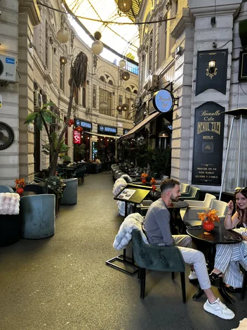 Bemolle terrace and Trio sign beneath the glass roof in Macca–Villacrosse Passage.