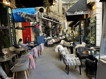 Valea Regilor sign and café terraces in Bucharest’s Macca–Villacrosse Passage.