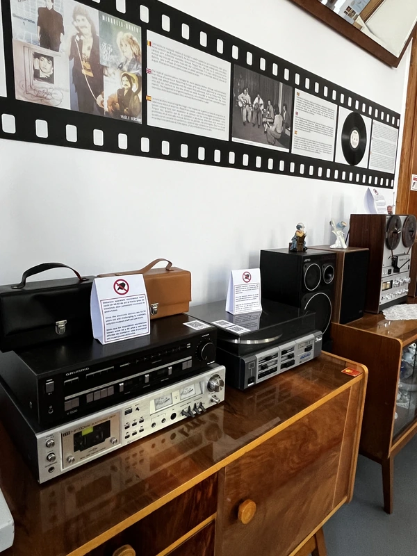 Old audio equipment on a wooden cabinet with preservation notices.