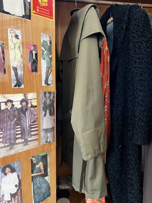 Vintage coats and dresses beside photographs illustrating fashions of the period.
