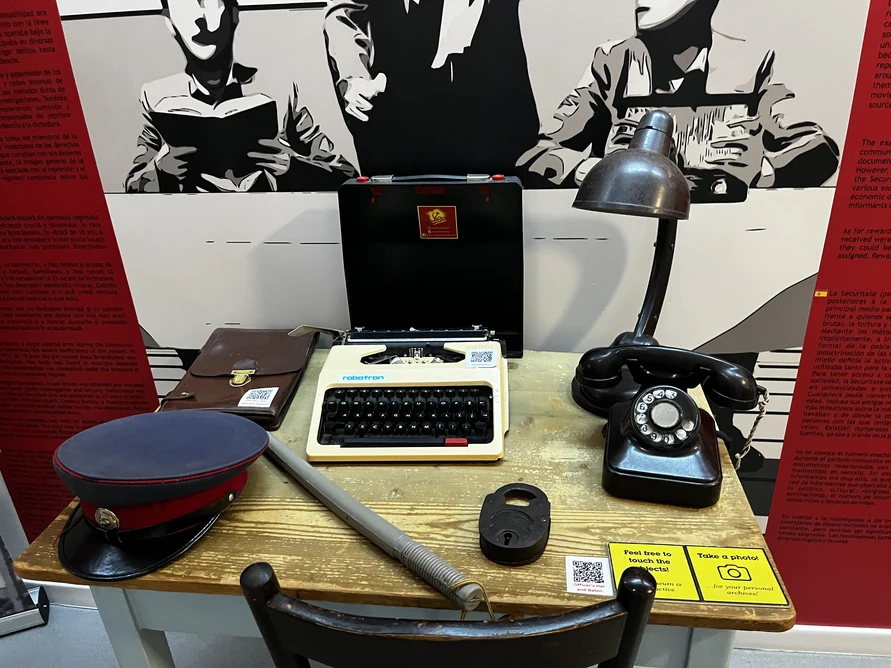 Typewriter, rotary telephone, peaked cap and documents on the militia and Securitate desk display.