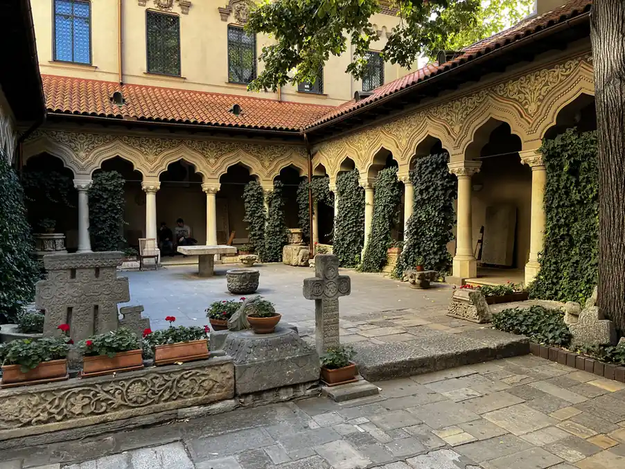 Arcaded galleries, carved columns and flowerpots around the Stavropoleos courtyard.