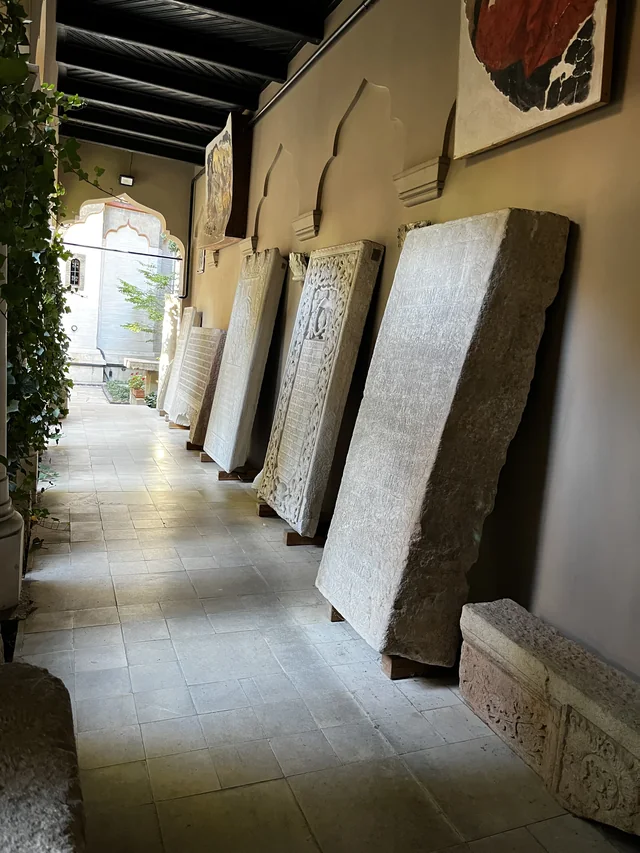 Inscribed stone slabs and carved tombstones in a covered gallery at Stavropoleos Monastery.